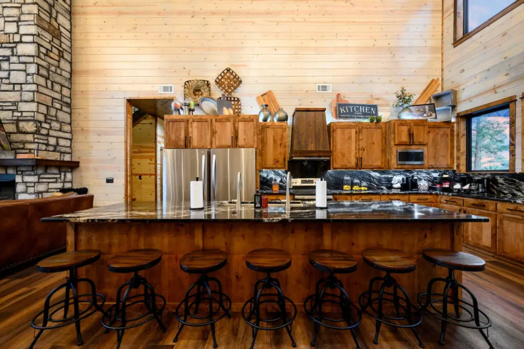 This gorgeous log cabin kitchen has an island that seats seven and flows into the open living space with those amazing views.