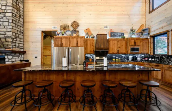 This gorgeous log cabin kitchen has an island that seats seven and flows into the open living space with those amazing views.