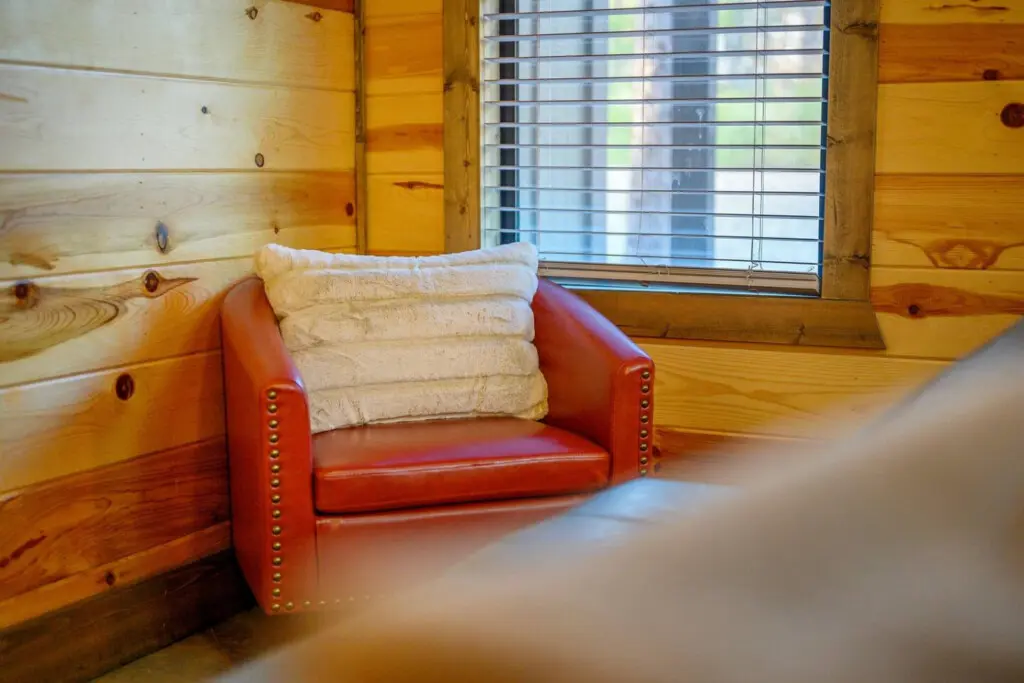 This cozy nook tucked into the log cabin is basically the perfect spot to curl up with a book and watch the light filter through those cabin windows.