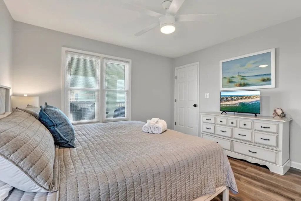 This master bedroom is basically the coastal retreat of your dreams—serene, spacious, and with those ocean views and sliding glass doors that make waking up feel like pure luxury.