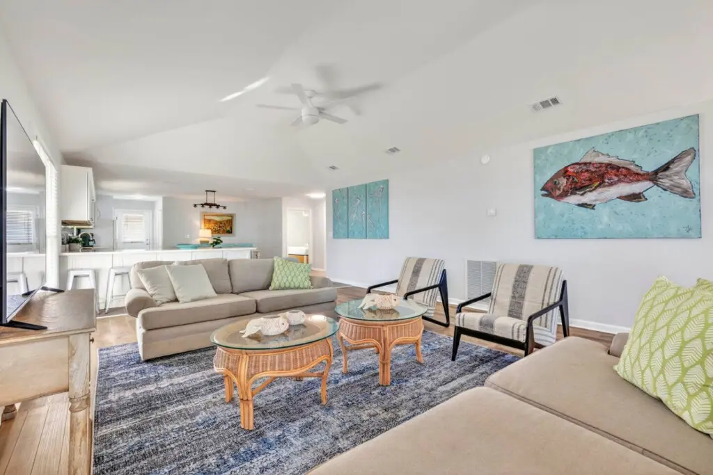 This breezy coastal living room is built for relaxation with its airy layout, natural light, and seamless flow to the kitchen—the perfect setup for those days when you never want to leave your seat.