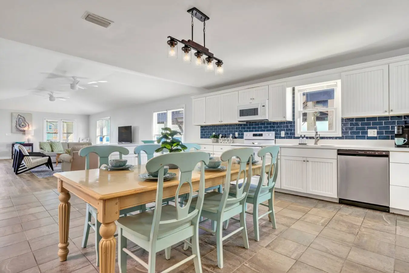 This bright, airy kitchen and dining space is exactly where the whole crew naturally gravitates—with plenty of room to cook together, gather around that gorgeous wood table, and soak in all those coastal vibes while you're making memories.
