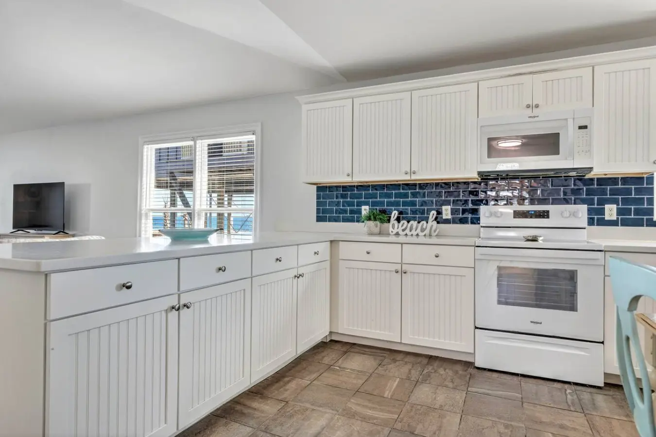 This bright, updated kitchen with its crisp white cabinetry and coastal charm is perfectly set up for whipping up meals between beach days—complete with everything you need and those ocean views to keep you company while you cook.