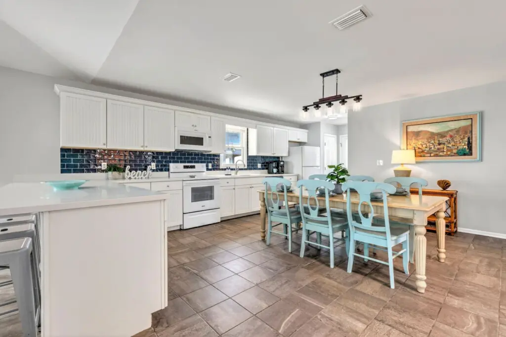 This sunny kitchen and dining space is basically the heart of the home—with plenty of room to gather around the table, easy flow to cook up whatever you're craving, and that bright, breezy coastal vibe that makes every meal feel a little bit special.