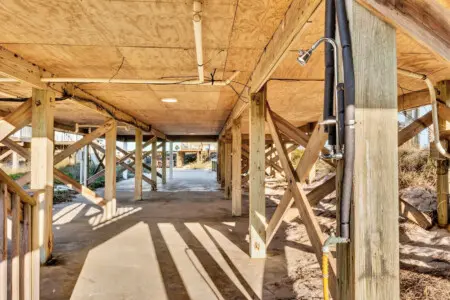 Step underneath this airy covered structure and you've got the perfect blend of beach access and shade—it's basically your own private gateway to the sand with all the comforts of home just steps away.