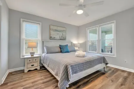 Wake up to soft coastal light streaming through those shutters and a gentle breeze from the ceiling fan—this peaceful bedroom is your perfect beachside escape where comfort meets seaside serenity.