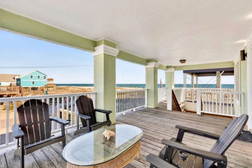 Imagine spending your entire beach vacation on this sprawling covered deck—multiple lounge spots, unobstructed ocean views, and that perfect coastal breeze that makes you never want to go inside.