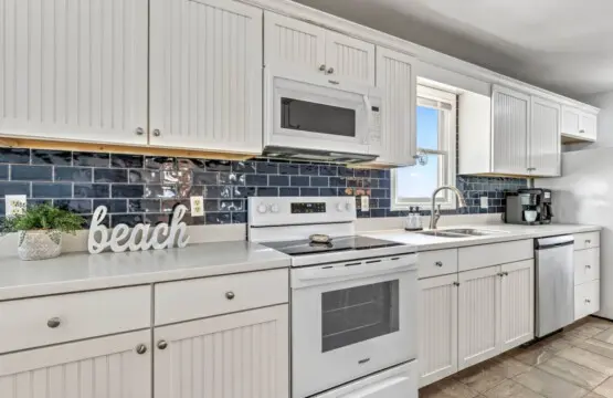 This spotless, bright kitchen with its crisp white cabinetry and dark subway tile backsplash is basically your beachside cooking headquarters—packed with everything you need to whip up meals and snacks between beach days.