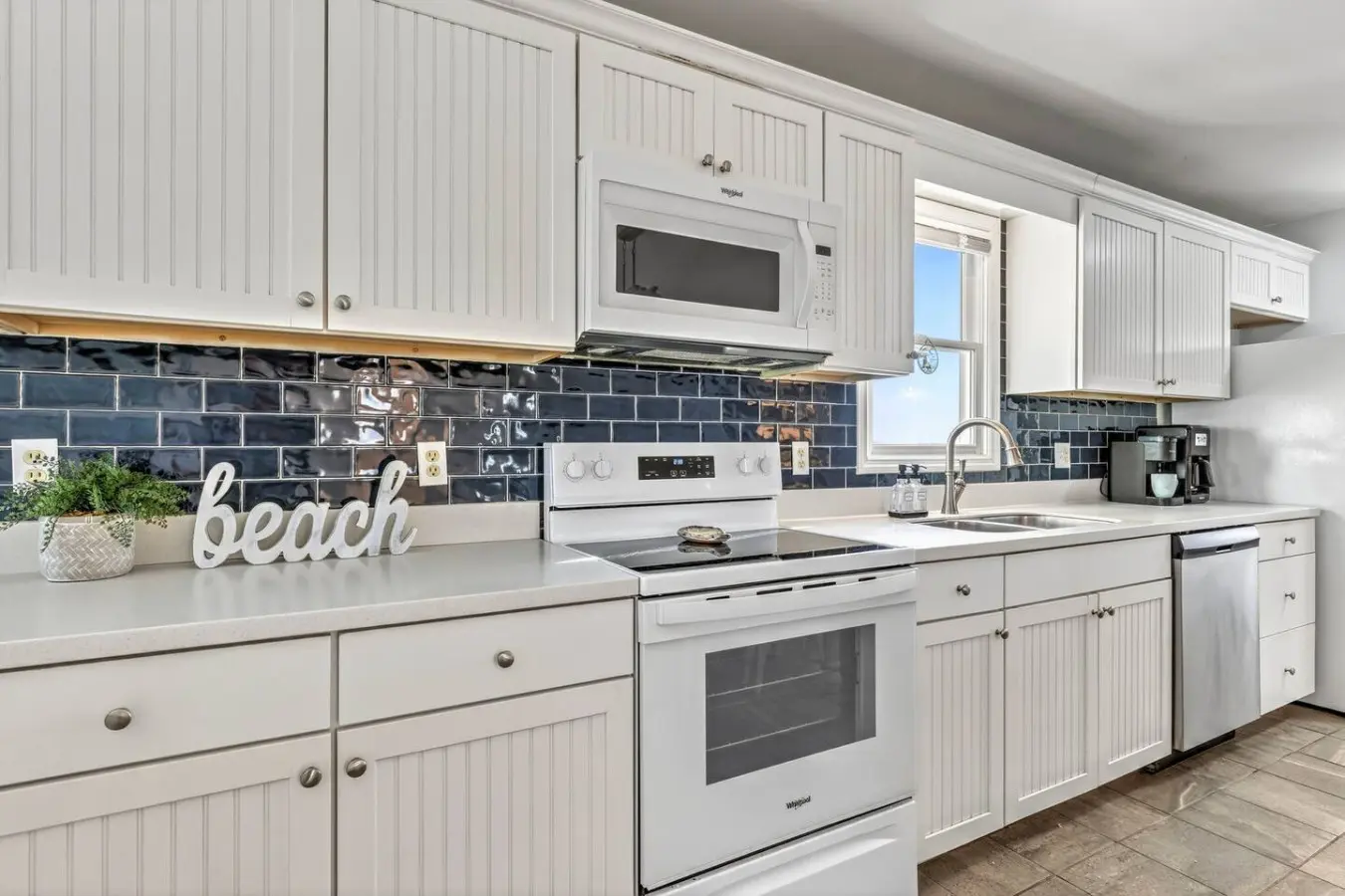 This spotless, bright kitchen with its crisp white cabinetry and dark subway tile backsplash is basically your beachside cooking headquarters—packed with everything you need to whip up meals and snacks between beach days.
