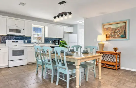 This spacious, light-filled kitchen and dining area is where all the magic happens—plenty of counter space for cooking together, comfortable seating for the whole crew, and that breezy coastal flow that makes every meal feel special.