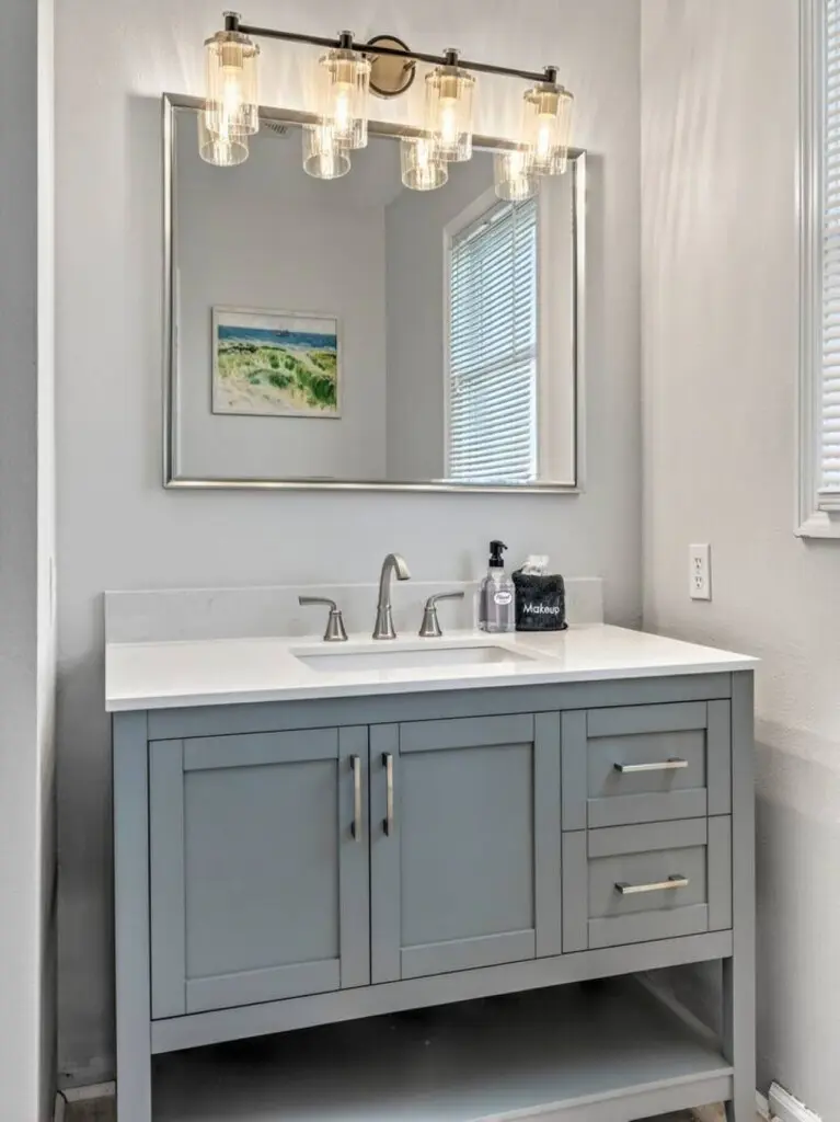 This fresh, bright bathroom with its elegant vanity and beautiful lighting is the perfect spot to freshen up between beach days.