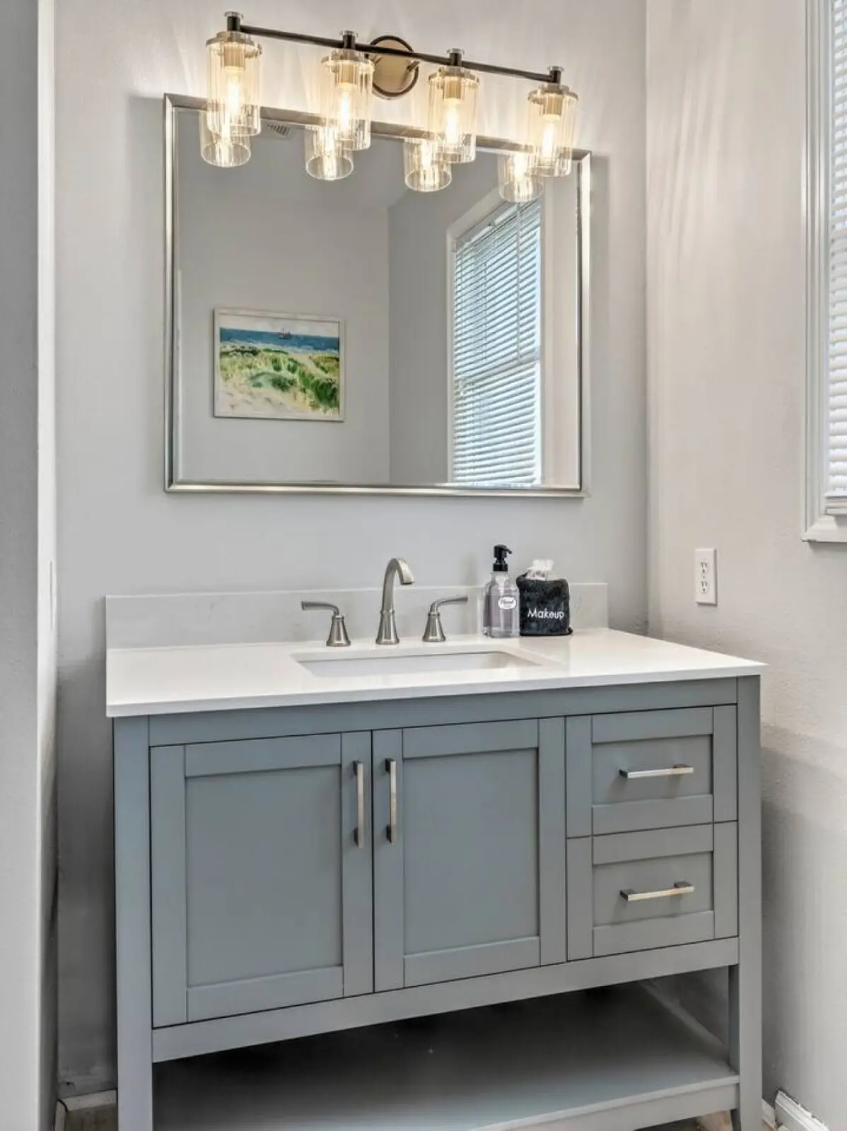 This fresh, bright bathroom with its elegant vanity and beautiful lighting is the perfect spot to freshen up between beach days.