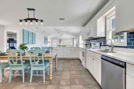 This bright, inviting kitchen and dining area is basically where the whole crew will want to hang out—plenty of space to cook together, gather around that beautiful wood table, and soak in all the light and coastal charm that makes every meal feel like pa