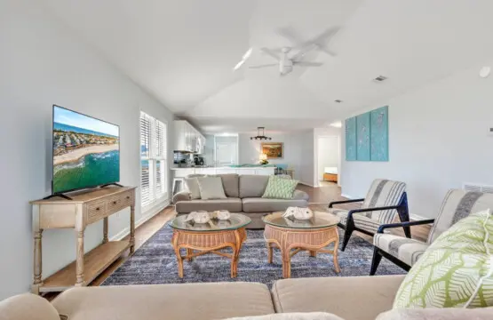 This spacious open-concept living room is basically made for those lazy beach days—tons of natural light, comfy seating for the whole crew, and easy flow straight to the kitchen whenever the mood strikes.