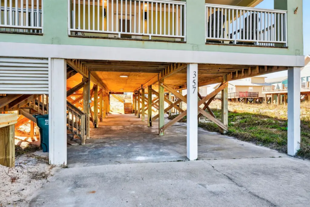 Step straight out of the house and into the sand with this incredible under-home setup—it's basically your private passage to the beach with direct access and that perfect mix of shade and ocean air.