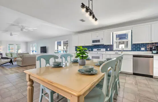 This open, sun-drenched kitchen and dining area is basically built for making memories—whether you're cooking up a feast together or just gathering around that beautiful wood table, the whole space flows seamlessly from cooking to eating with that relaxed