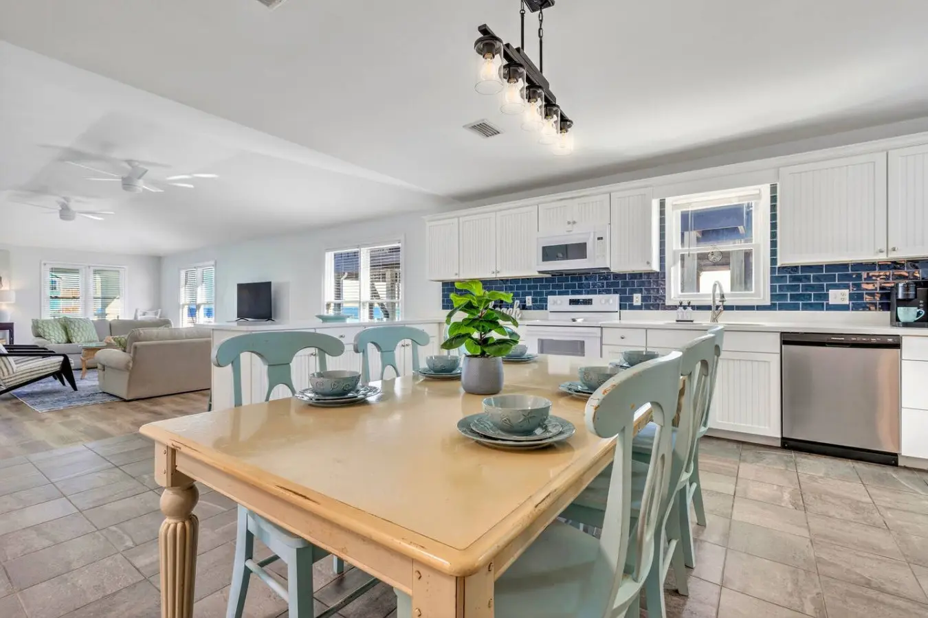 This open, sun-drenched kitchen and dining area is basically built for making memories—whether you're cooking up a feast together or just gathering around that beautiful wood table, the whole space flows seamlessly from cooking to eating with that relaxed