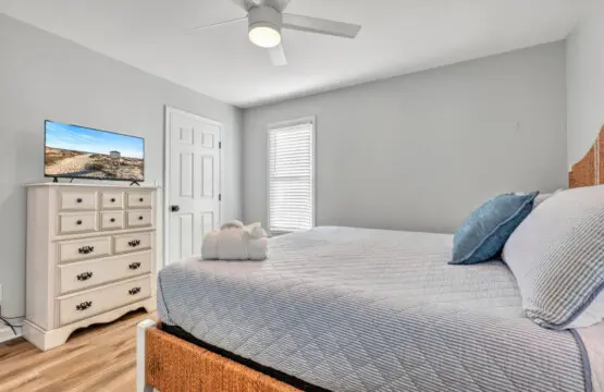 Wake up in this calm, light-filled bedroom with everything you need for a perfect night's sleep—soft bedding, a gently spinning ceiling fan, and that peaceful coastal quiet that makes you never want to leave.