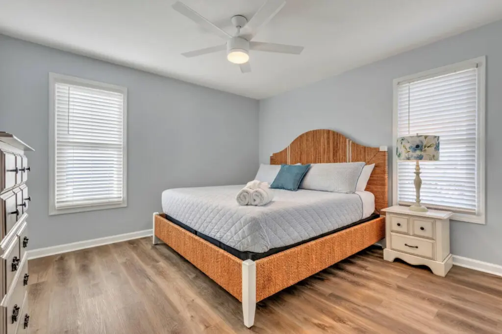 Wake up in this serene coastal bedroom where soft natural light filters through the shutters and a ceiling fan keeps the ocean breeze flowing all night long.