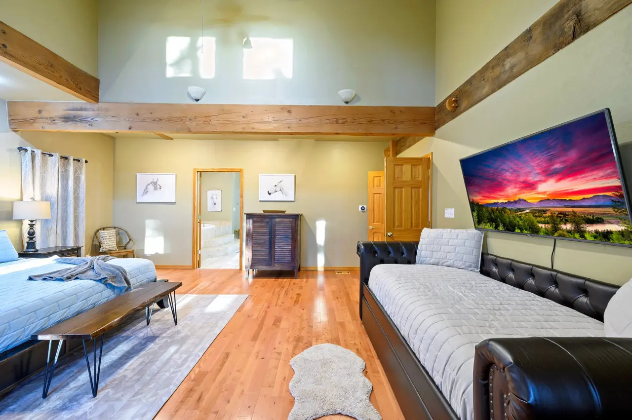 Relax and recharge in our cabin bedroom, where a cozy couch and television offer the perfect escape after a day of adventure.