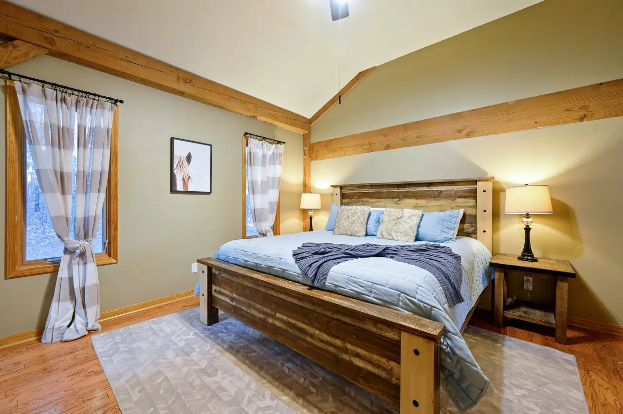 Step into our cabin bedroom and discover a blend of natural beauty and refined comfort, creating a haven for relaxation.