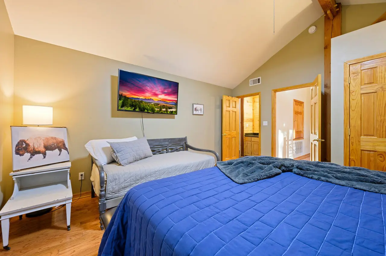 Retreat to our cabin bedroom oasis, where a plush couch and television provide the ideal space to unwind, recharge, and indulge in some well-deserved rest.