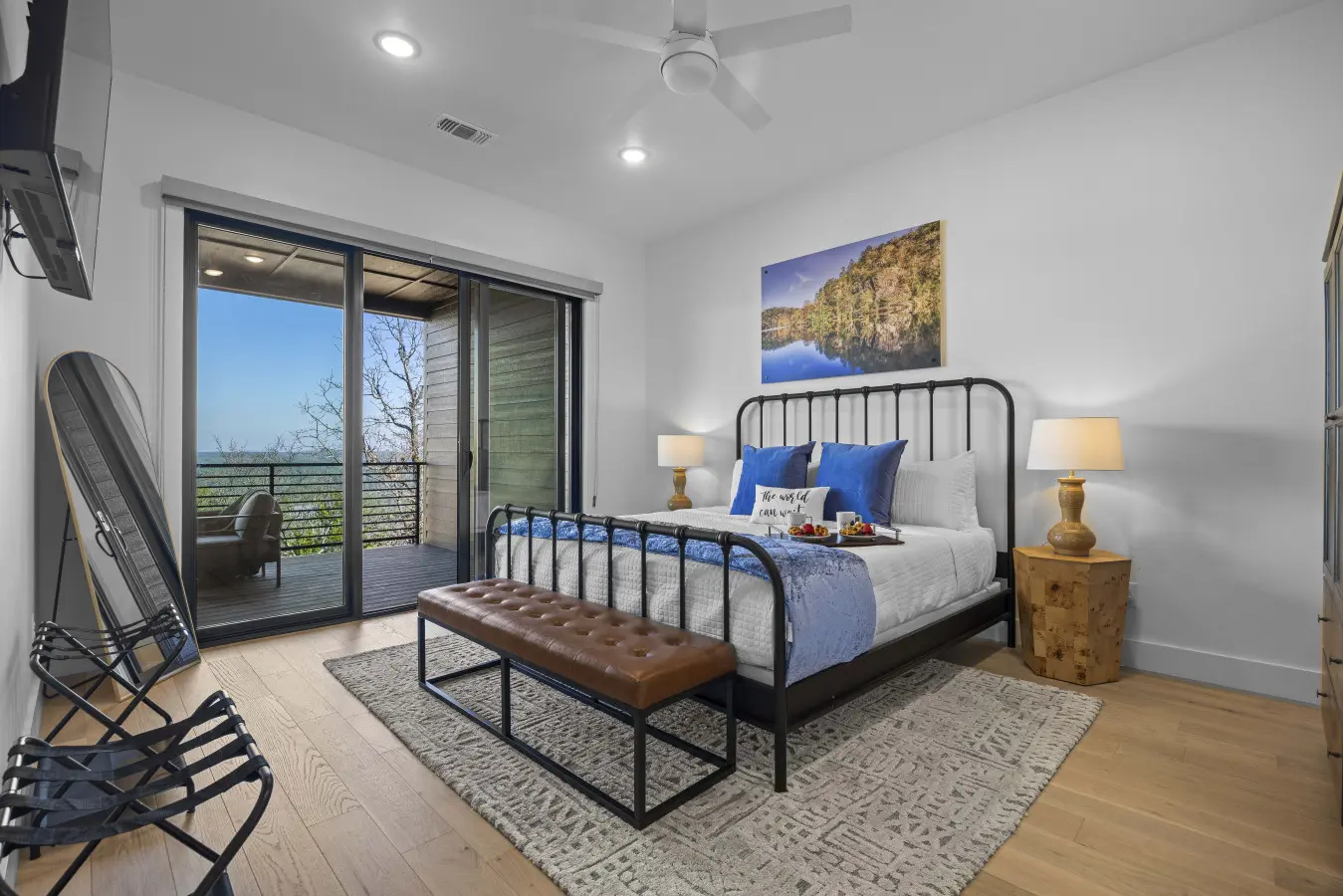 Wake up to forest views from the balcony in this king suite with its cozy iron bed.