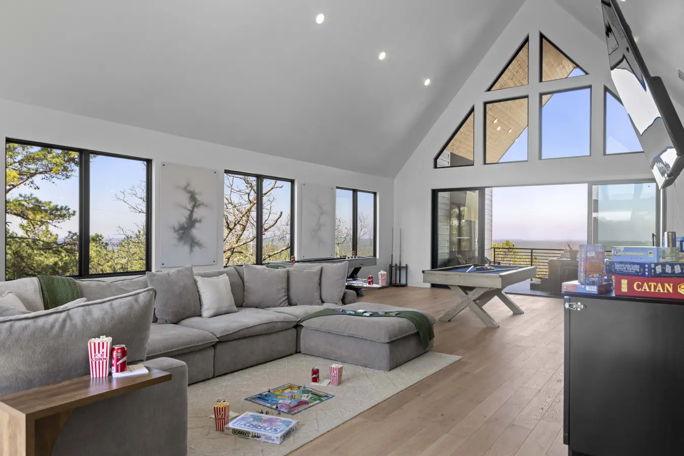 Game night sorted with Catan, a pool table, and that massive sectional—plus views for days through those A-frame windows.