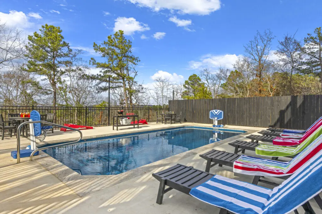 Lounge chairs, a pool basketball hoop, and colorful towels ready to go—this heated pool setup is made for lazy afternoons.