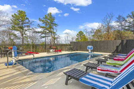 Lounge chairs, a pool basketball hoop, and colorful towels ready to go—this heated pool setup is made for lazy afternoons.