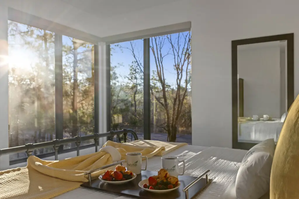 Wake up to floor-to-ceiling windows framing pristine forest views from your private bedroom sanctuary.
