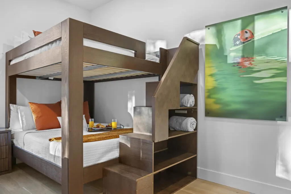 Bunk room with a full staircase and built-in storage — every inch of this room works hard.
