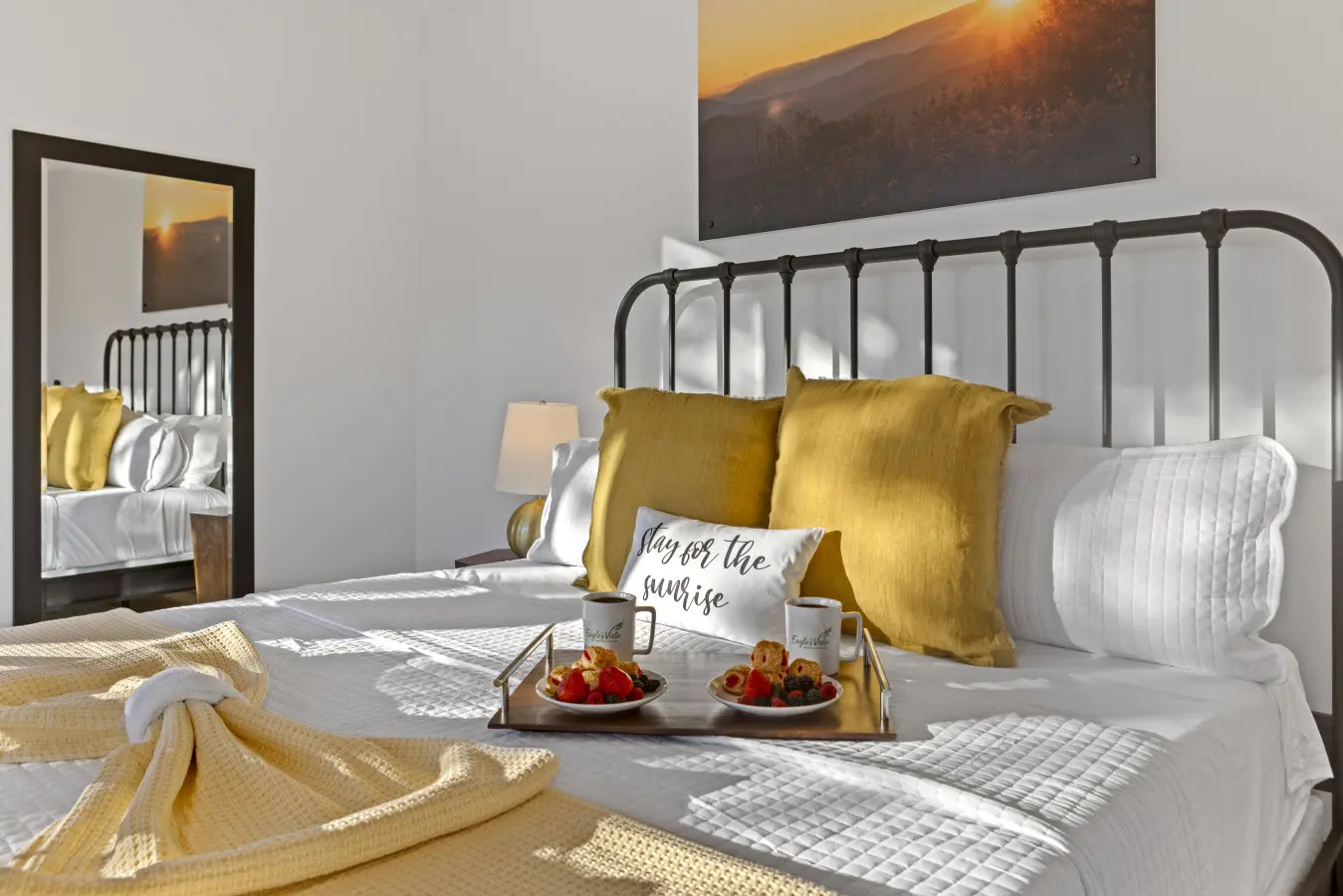 Wake up to mountain views and golden sunlight streaming through this bright, airy bedroom with its charming metal bed frame.