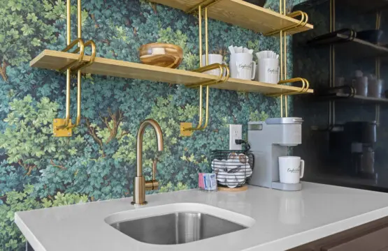 The wet bar's got a Keurig, custom Eagle's Vista mugs, and that botanical wallpaper is a whole vibe.