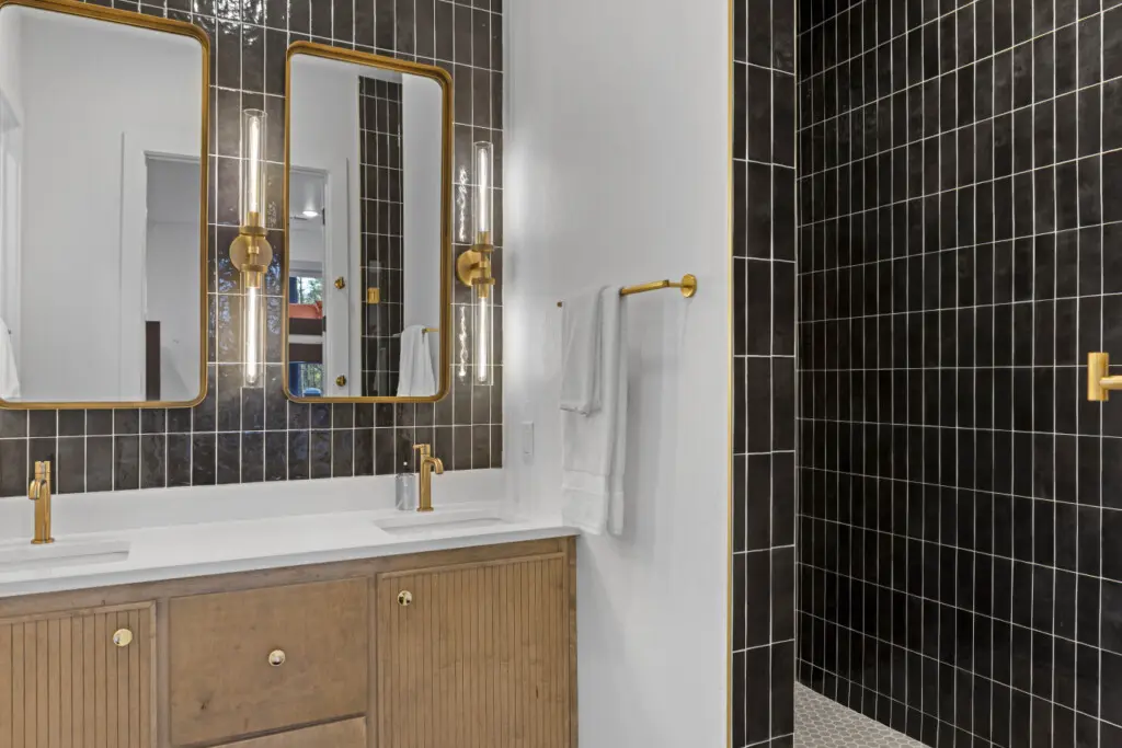 The black tile and gold hardware in this bathroom give it that moody boutique hotel vibe.