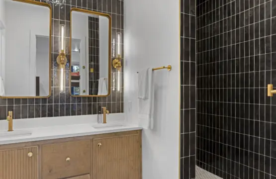 The black tile and gold hardware in this bathroom give it that moody boutique hotel vibe.