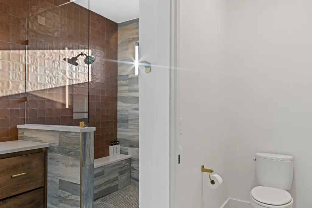 This master bath features a spacious walk-in shower with premium tile, dual vanities, and stunning natural light.