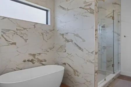 That freestanding soaking tub and walk-in shower with the marble-look tile is giving serious spa energy.