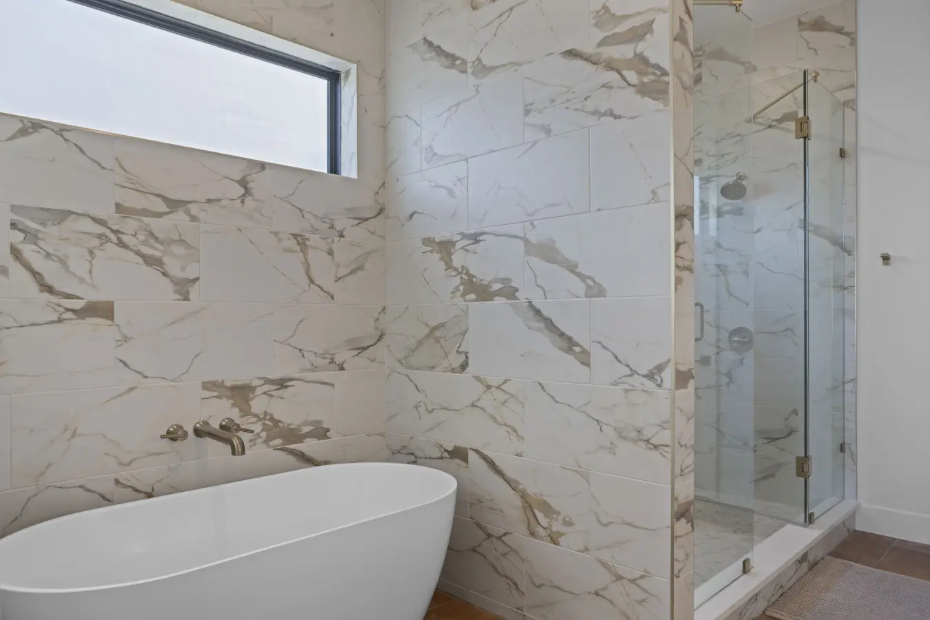 That freestanding soaking tub and walk-in shower with the marble-look tile is giving serious spa energy.