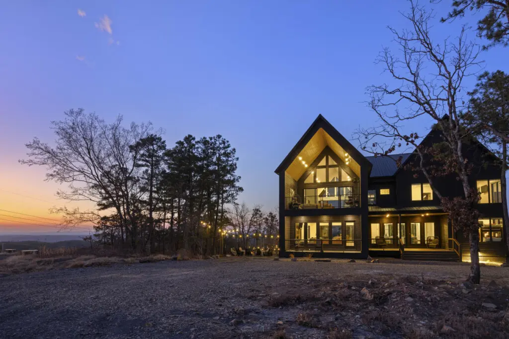 Eagle's Vista glowing at twilight with string lights by the fire pit and that signature A-frame framing the sunset.