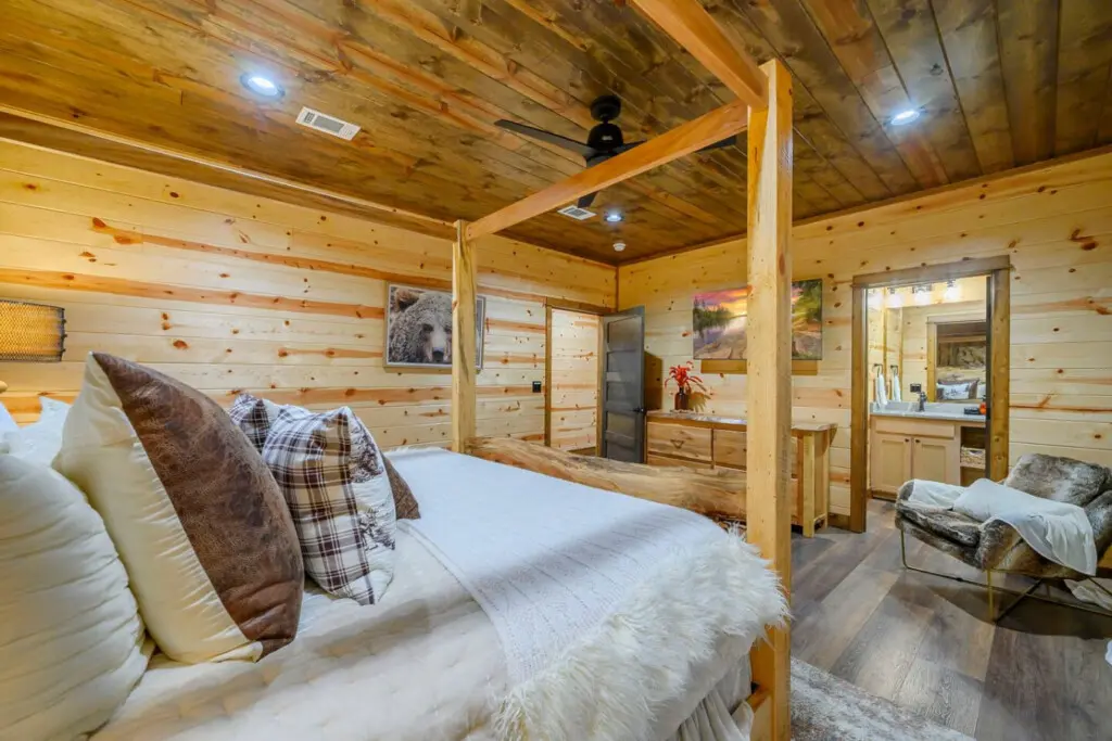 This cozy log cabin bedroom features a gorgeous wooden four-poster bed with rustic charm and modern comfort throughout.