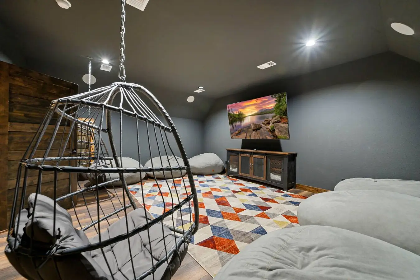 This epic hangout room features a suspended egg chair, multiple beds, and a cozy entertainment setup perfect for groups.