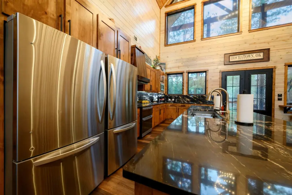 This gorgeous kitchen features stainless steel appliances, dark granite countertops, and soaring wood ceilings with tons of natural light.