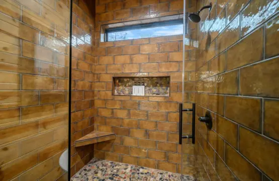 Gorgeous walk-in shower with warm tile work and a skylight that floods the space with natural light.