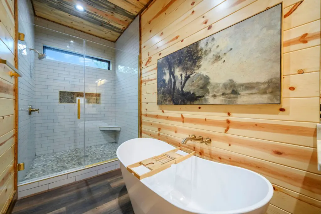 This spa-like primary bath features a soaking tub, walk-in shower, and rustic wood walls that'll make you never want to leave.