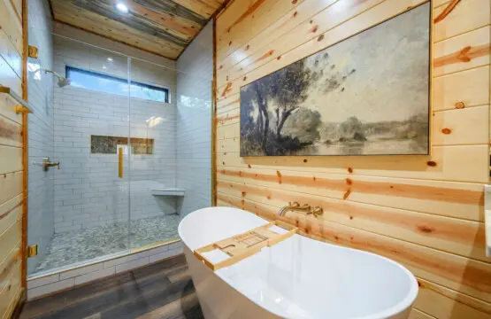 This spa-like primary bath features a soaking tub, walk-in shower, and rustic wood walls that'll make you never want to leave.