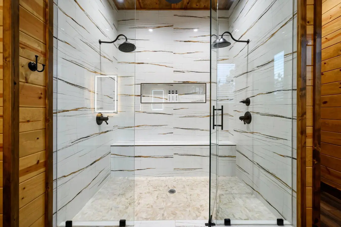 This spa-like walk-in shower with heated floors and dual rainfall showerheads is basically a luxury hotel experience in your own bathroom.