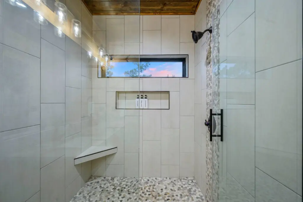 This spa-like shower features a scenic window view, heated floors, and luxe finishes that'll make your morning routine feel like a resort experience.