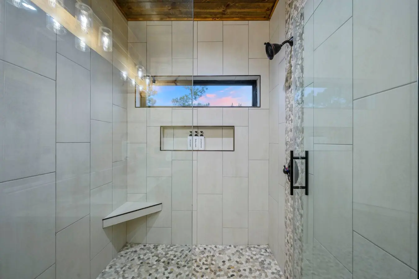 This spa-like shower features a scenic window view, heated floors, and luxe finishes that'll make your morning routine feel like a resort experience.