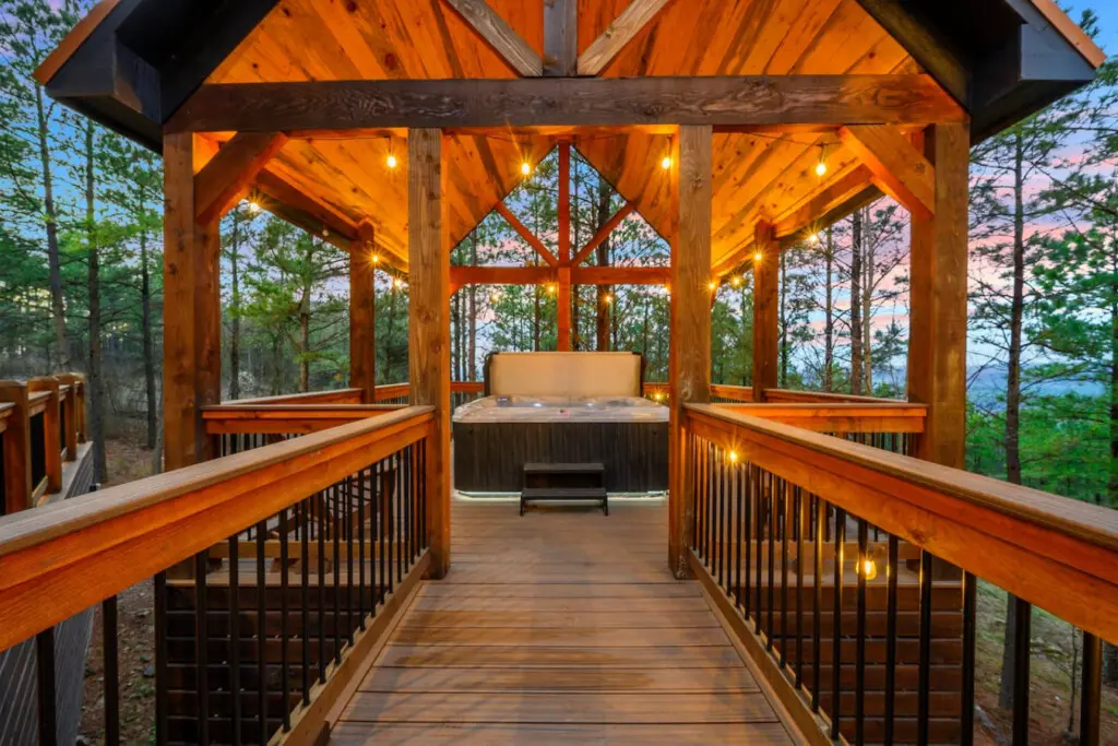 This stunning timber-framed hot tub gazebo overlooks the forest with ambient lighting and endless mountain views.
